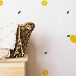 Gros plan sur un panier en rotin avec des couvertures. Pour une décoration de chambre d'enfant avec des autocollants en formes de citrons.